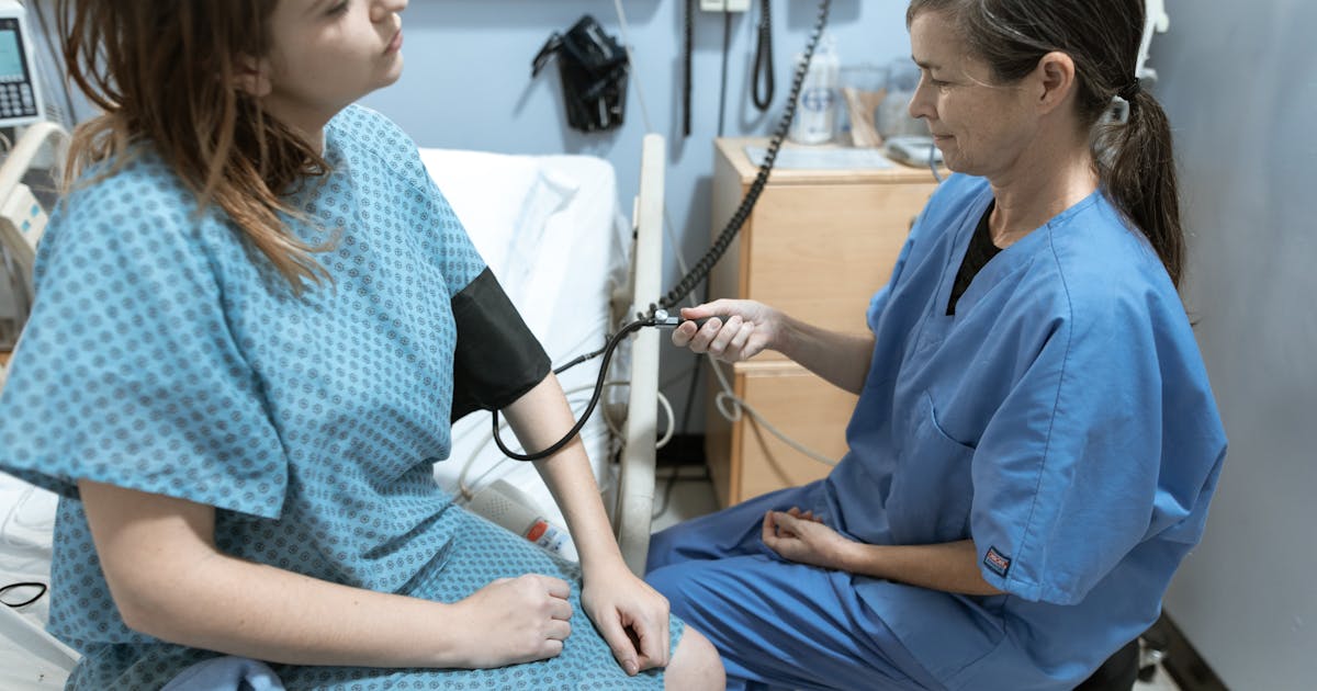 Nurse checking patient blood pressure in skilled nursing facility